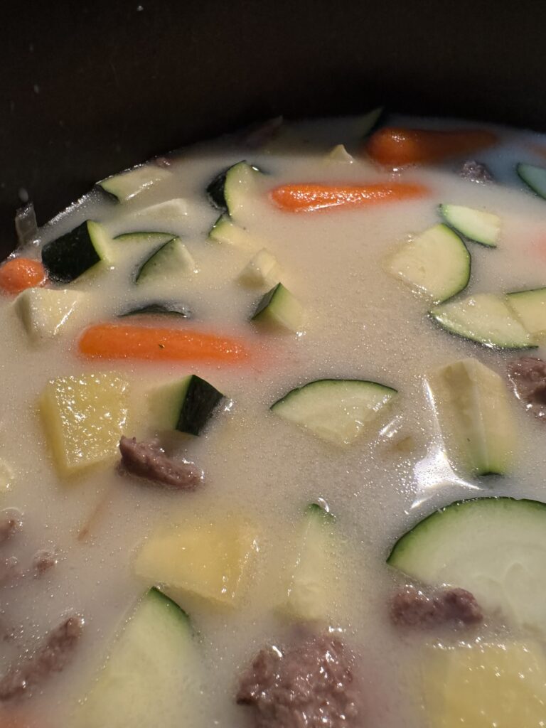 This is a close up of the creamy, dairy free ground turkey soup. You can see the coconut melted with the chicken broth and the vegetables floating in the soup. So yummy!