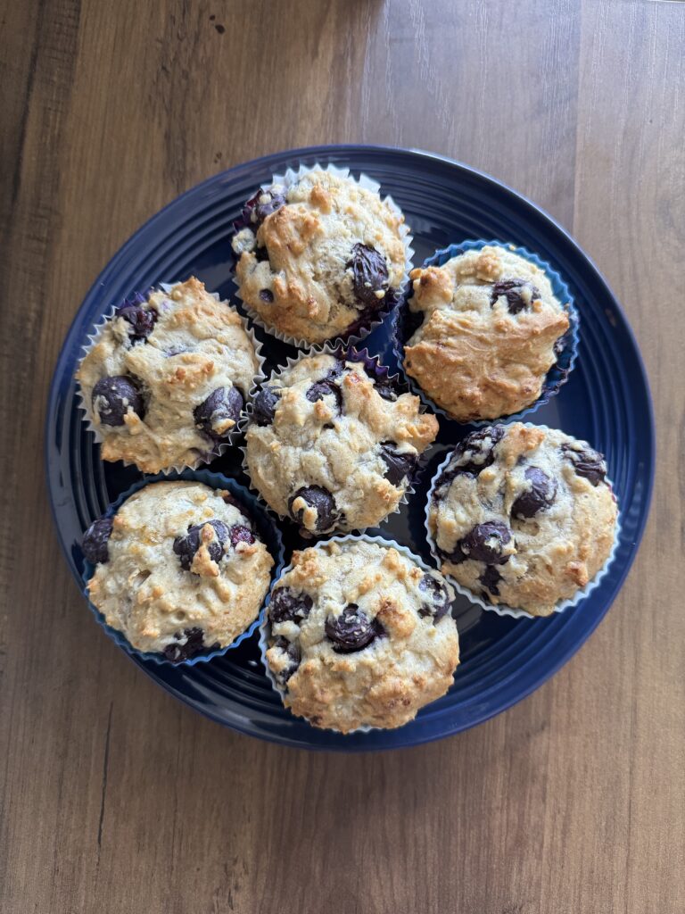 This image is a plate of gluten free blueberry muffins. There are 7 muffins on this plate.